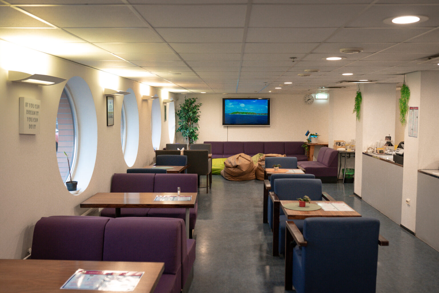 Herne Kohviku sisekujundus valgete seinte ja taimede dekoratsiooniga