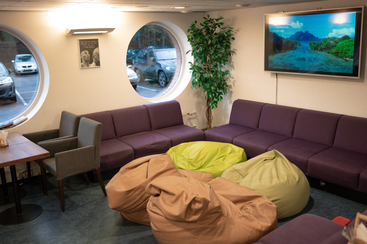 Herne Kohviku ühisvaatamiste ala kott-toolide, lillade diivanite ja televiisoriga